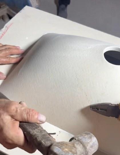 A finished basin being struck with a hammer during strength testing